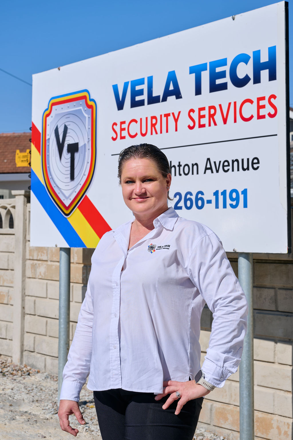 Five uniformed Vela-Tech security officers standing beside a response vehicle
