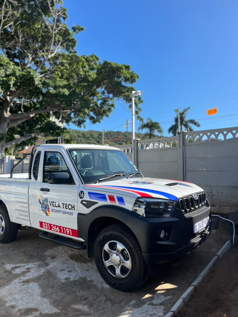 A Vela-Tech Security branded patrol vehicle parked outside a client site